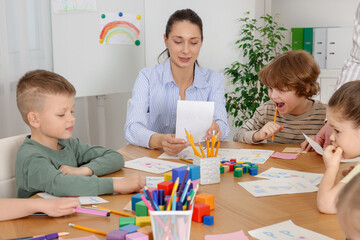 Fototapeta premium Children having lesson with teacher at desk indoors
