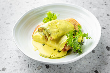 A tender chicken enchilada smothered in vibrant green sauce, garnished with fresh lettuce, elegantly presented on a white plate, perfect for showcasing flavorful Mexican cuisine.