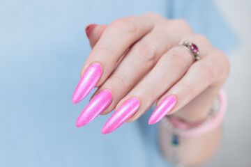 Fototapeta premium Female hands with long nails and neon pink nail polish