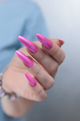Female hands with long nails and neon pink nail polish