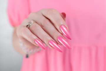 beautiful female hands with long nails and bright neon pink red nail polish