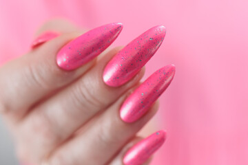 beautiful female hands with long nails and bright neon pink red nail polish