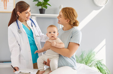 Young mother parent sitting with cute toddler child baby and talking with smiling friendly...