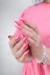 beautiful female hands with long nails and bright neon pink red nail polish