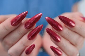 Female hand with long nails and a bright red manicure