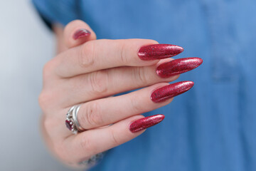 Female hand with long nails and a bright red manicure