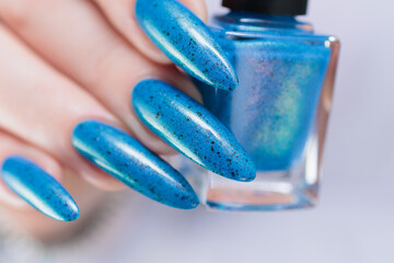 Woman's beautiful hand with long nails and bright blue manicure