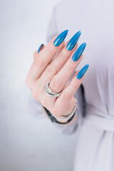 Woman's beautiful hand with long nails and bright blue manicure