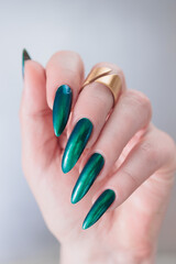 Woman's beautiful hand with long nails and blue and green nail polish