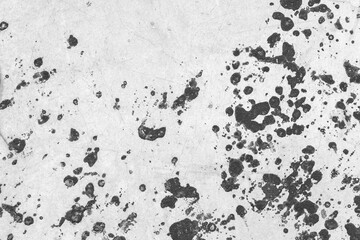High-contrast black paint splatter texture on a gray concrete background