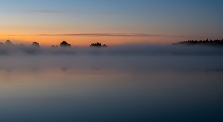 Misty Lake Landscape at Sunrise Reflecting Sky and Trees