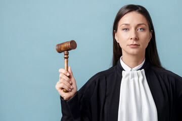 Judge with mallet on light blue background, space for text