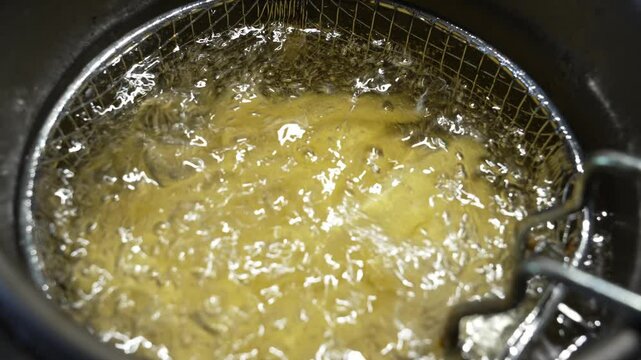 Potatoes cooking into heated vegetable oil in a deep fryer. cooking in hot oil.