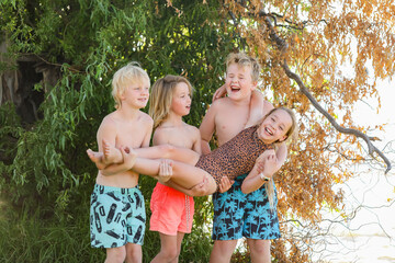 Happy kids hanging out in swimsuits in golden summer sun