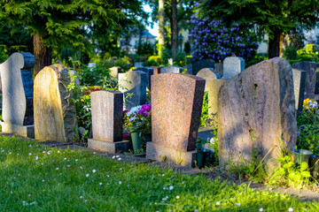 Back of several gravestones in a cemetery. No personal data can be seen.