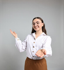 Happy businesswoman welcoming clients or partners on grey background. Space for text