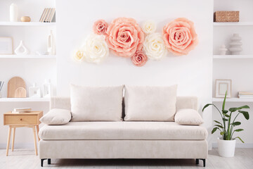 Beautiful decorative paper flowers on wall in room