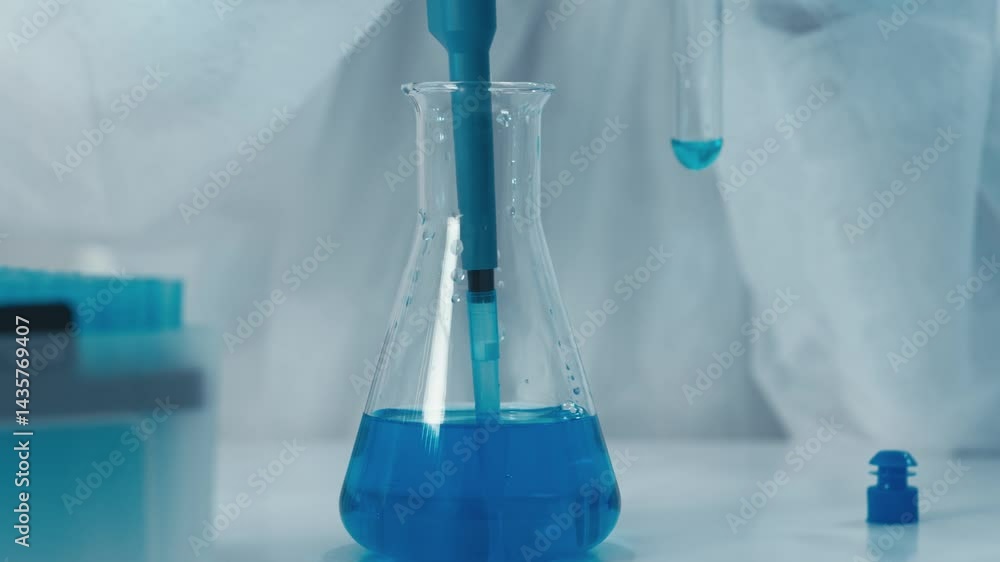Poster a skilled lab technician transfers a vibrant blue liquid from a calibrated pipette into a sanitized 