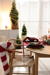 Christmas table setting with stylish dishware and festive decor indoors