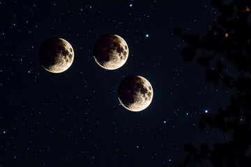 Fototapeta premium Three full moons shining brightly in a starry night sky