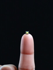 Microchip on a Human Finger with Fingerprint Details Against a Dark Contrasting Background