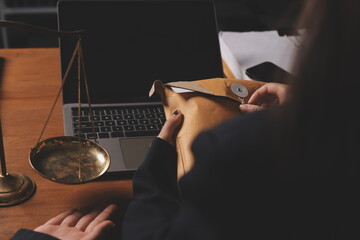 Attractive young lawyer in office Business woman and lawyers discussing contract papers with brass scale on wooden desk in office. Law, legal services, advice, Justice and real estate concept.
