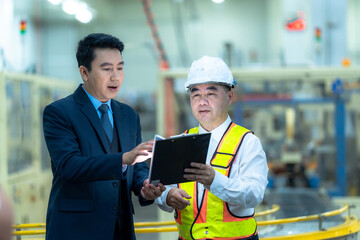 Asian team of engineers and factory supervisors are inspecting the production line in a factory that produces industrial products such as electronics, food, packaging in a modern factory.