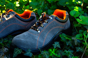 Blue Safety boots with non-slip soles on grass and stones. These safety shoes for men offer both...