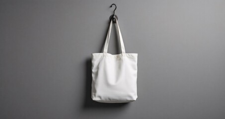 Totebag hanging on monochrome grey wall, clean and symmetrical setup with soft studio lighting. Great for mockup or product branding presentation.