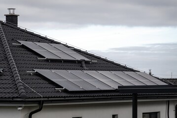 Grey roof with solar panels to generate green renewable energy in overcast weather
