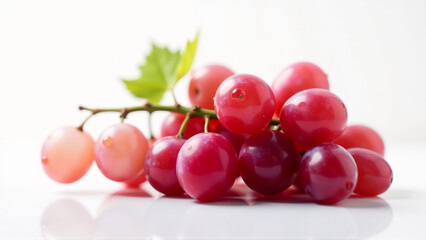 Lush Bunch of Red Grapes with Water Droplets on White Reflective Surface