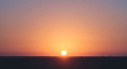 Dawn sun peeking over the horizon with cinematic glow