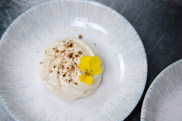 Elegant dessert garnished with edible flowers on a porcelain plate