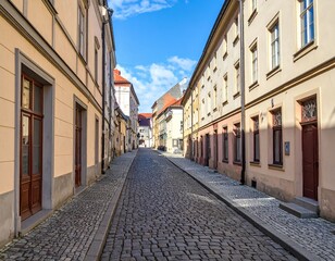 Fototapeta premium Cobblestone Street in European Town with Historic Buildings on Sunny Day