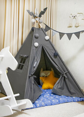 Playroom with Teepee. Modern room interior with play tent for child. children's wigwam in the room on the floor Scandinavian style with decor. children's play area © Nataliia