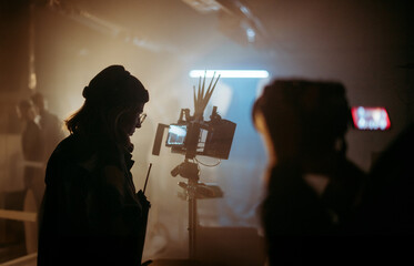 A female director at work on the set. The director works with a band or with a speaker during the...