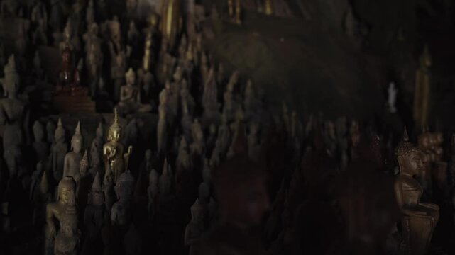 Hundreds of Buddha statues fill the sacred Pak Ou Caves in Laos, creating a mesmerizing spiritual scene surrounded by ancient limestone cliffs and quiet reverence. 4k video footage