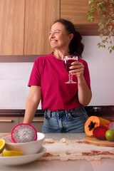 mulher de 50 anos bebendo suco natural de frutas vermelhas