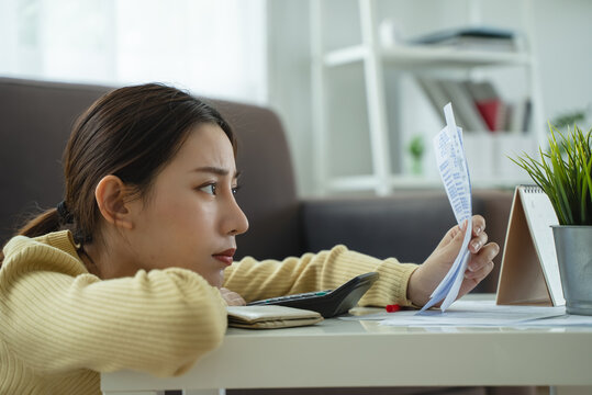 stressed young asian woman trying to find money to pay credit card deb
