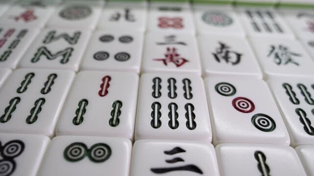 Close-up of Mahjong tile set,Mahjong is a tile-based game from 19th-century China that has gained global popularity since the early 20th century,4k,slow-motion,truck camera movements