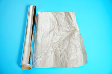 A roll of baking foil on a blue background.