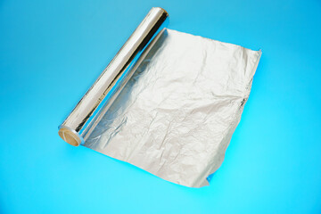 A roll of baking foil on a blue background.