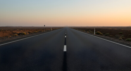 Naklejka premium Open Asphalt Road Stretching Towards Distant Horizon During Twilight Journey
