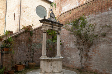Old medieval well in the Saint Catherine neighborhood, Siena, Italy.