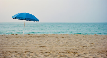 Solitary Blue Umbrella Casting Shade on a Tranquil Beach Scene