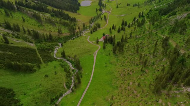 Luftaufnahme Wanderweg entlang des Faltenbachs durch ein von hohen Bergen umgebenes Tal zur Nebelhornspitze bei Oberstdorf im Allgaeu, Bayern, Deutschland. Luftbild alpines Naturerlebnis pur. 