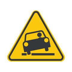 Isolated yellow caution triangle on roadside warns drivers to stay clear of the edge&mdash;ditch or trench hazard near rural road