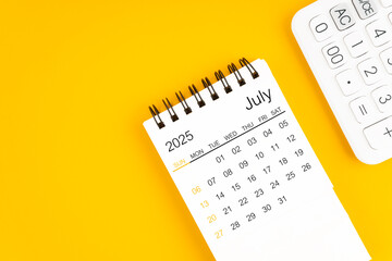 July 2025 calendar and calculator on yellow background.
