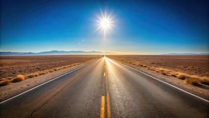 Fototapeta premium Asphalt ribbon cutting through a sun-drenched arid landscape, leading towards a distant mountain range under a brilliant blue sky