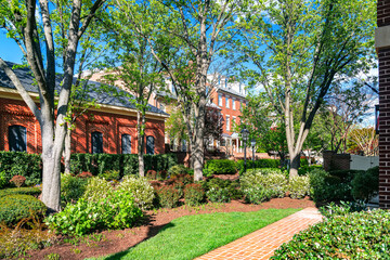 landscaped recreation area in a public courtyard with a red brick sidewalk.